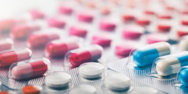 Heap of medical pills in white, blue and other colors. Pills in plastic package. Panoramic banner for design.